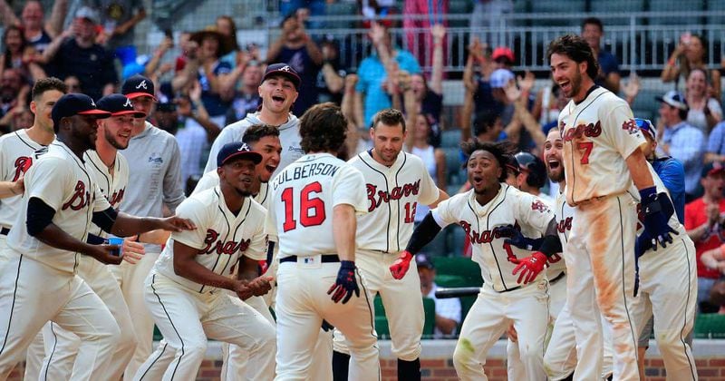 Braves teammates wait for Charlie Culberson to cross home plate on a walk-off homer. (AP photo)
