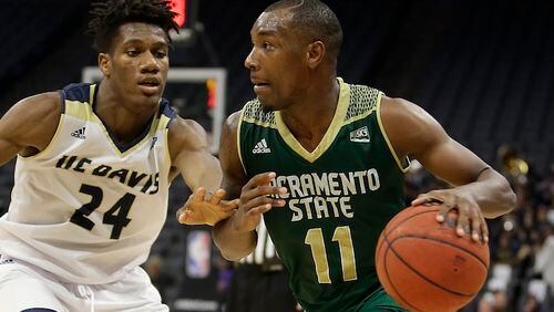 In this photo taken Tuesday, Nov. 21, 2017, Sacramento State guard Kevin Hicks, right, drives against UC Davis guard Delveion Jackson during the second half of an NCAA college basketball game in Sacramento, Calif. Hicks broke down in his first trip back to the 9th Ward of New Orleans since Hurricane Katrina uprooted his family. The bones are what hit Hicks. Not the house that was destroyed, not the devastation still apparent three years later, not the clothes wadded up in the corner of what was once his bedroom. No, the bones of the family dog scattered in the yard are what did it. (AP Photo/Rich Pedroncelli)