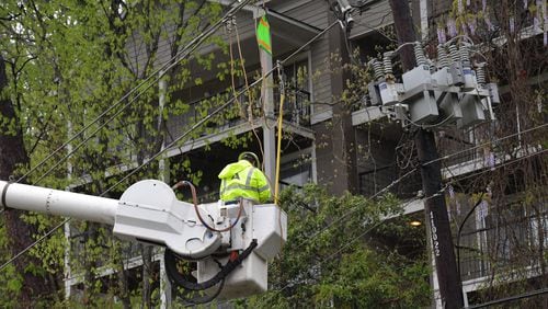A Georgia Power crew repairs storm damage in Roswell in this April file photo. HYOSUB SHIN / HSHIN@AJC.COM