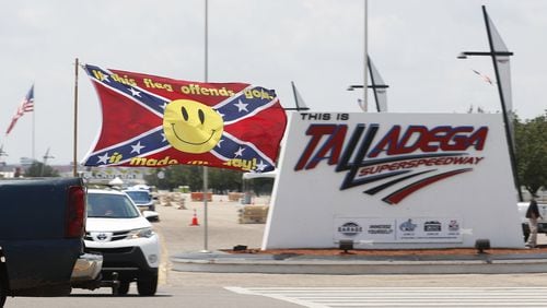 Race fans fly Confederate battle flags and United States flags as they drive by the entrance to Talladega Superspeedway prior to a NASCAR Cup Series auto race in Talladega Ala., Sunday, June 21, 2020.. (AP Photo/John Bazemore)