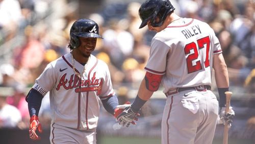 Atlanta Braves' Ozzie Albies, left, celebrates his solo home run with Austin Riley during the first inning of a baseball game against the San Diego Padres in San Diego, Saturday, April 16, 2022. (AP Photo/Kyusung Gong)