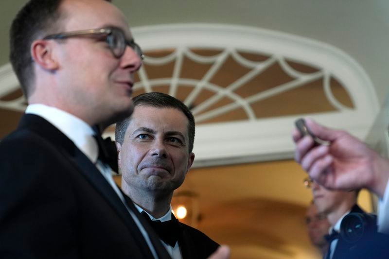 Transportation Secretary Pete Buttigieg, right, listens as his husband Chasten Buttigieg, left, talks with reporter as they arrive for a State Dinner at the White House in Washington, Thursday, May 2, 2024, to honor the 2024 National Teacher of the Year and other teachers from across the United States. (AP Photo/Susan Walsh)