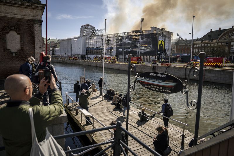 Firefighters work on the building after a fire broke out at the Stock Exchange in Copenhagen, Tuesday, April 16, 2024. The fire was reported Tuesday morning in the historic building, which was undergoing renovation. (Mads Claus Rasmussen/Ritzau Scanpix)