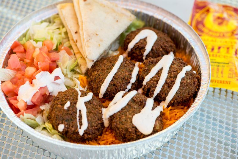  Falafel platter with rice, lettuce, tomato, grilled pita, and special white sauce from The Halal Guys. Photo credit- Mia Yakel.