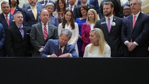 Gov. Brian Kemp signs a new package of human trafficking measures into law with his wife, Marty Kemp, at his side. The first lady made targeting human trafficking her top legislative priority after her husband was elected governor in 2018. Contributed