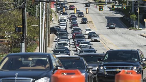 Traffic backs up along southbound Piedmont Road as construction crews clear debris on Sunday. Demolition is underway on the section of I-85 that collapsed in a fire Thursday evening. (DAVID BARNES / DAVID.BARNES@AJC.COM)