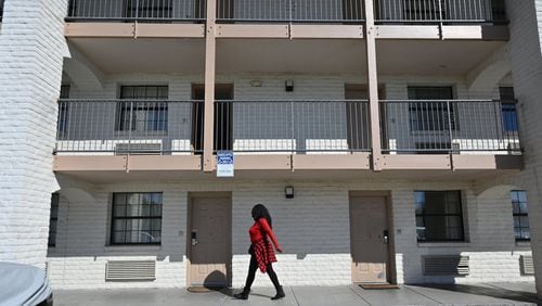 Resident walks below the window of an extended stay motel in Norcross. For low-wage workers, extended stay has been an alternative to homelessness, but many have lost their jobs. (Hyosub Shin / Hyosub.Shin@ajc.com)