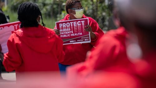 Dana Horton, a registered nurse at the Atlanta VA Medical Center and a representative of National Nurses United’s Atlanta chapter, protests with a handful of other nurses outside the Decatur hospital on Friday. Ben@BenGray.com for the Atlanta Journal-Constitution