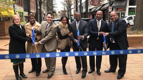 Mayor Kasim Reed along with other city officials cuts the ribbon on the new Broad Street Pedestrian Plaza, a gathering space with seating for restaurants and room for special events. CONTRIBUTED