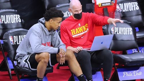Hawks forward John Collins confers with assistant coach Chris Jent while preparing to play the Philadelphia 76ers in Game 7 of the Eastern Conference semifinals on Sunday, June 20, 2021, in Philadelphia. (Curtis Compton / Curtis.Compton@ajc.com)