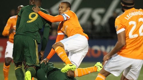 Houston Dynamo midfielder Ricardo Clark crashes through several Portland Timbers during the first half of an MLS soccer match Saturday, March 18, 2017, in Portland, Ore. (Pete Christopher/The Oregonian via AP)/The Oregonian via AP)