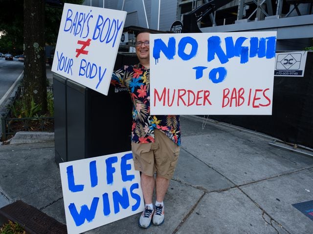 Charles Jones of Canton displays anti-abortion signs as abortion rights activists rally at Centennial Olympic Park in Atlanta on Friday, June 24, 2022. The protest follows the Supreme Court’s overturning of Roe v Wade. (Arvin Temkar / arvin.temkar@ajc.com)