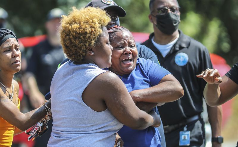 Distraught friends and family members at the scene of a triple shooting in southeast Atlanta that left a woman dead and two men injured.