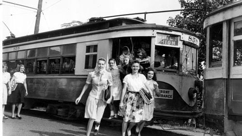 A group of girls dash toward the entrance of Girls High School in 1946, as the cars line up on their specially built tracks in the yard behind the building. Busing across town was necessary for girls and boys before community high schools were created in 1947.