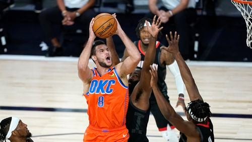 Oklahoma City Thunder's Danilo Gallinari (8) goes up for a shot as Houston Rockets' James Harden, center, and Danuel House Jr. (4) defend during the first half of an NBA basketball first round playoff game Saturday, Aug. 29, 2020, in Lake Buena Vista, Fla. (AP Photo/Ashley Landis)