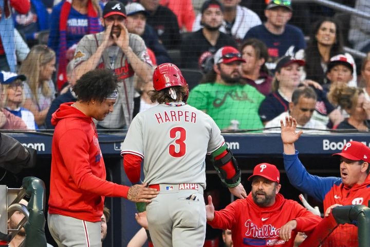 Philadelphia Phillies’ Bryce Harper (3) celebrates with teammates after scoring on a home run by catcher J.T. Realmuto during the third inning of NLDS Game 2 against the Atlanta Braves in Atlanta on Monday, Oct. 9, 2023.   (Hyosub Shin / Hyosub.Shin@ajc.com)