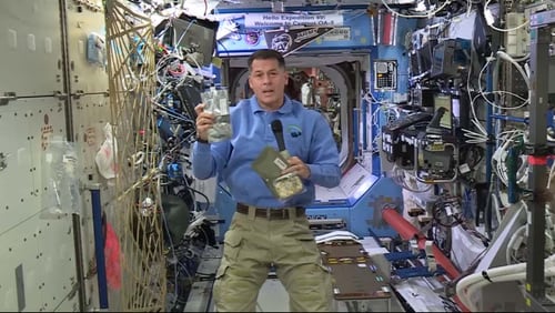 Atlanta astronaut Shane Kimbrough shows off Thanksgiving dinner that crew members eat on the International Space Station (ISS) while orbiting in space.