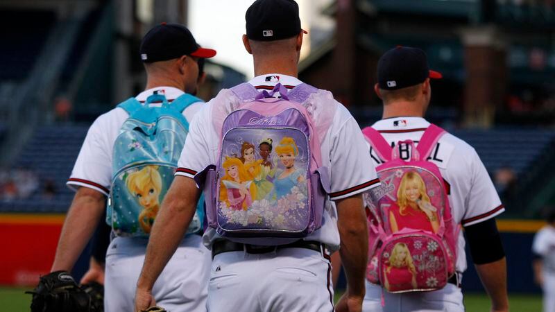 Braves rookie pitchers, including Jonny Venters (center) and Craig Kimbrel (right), head to the bullpen wearing children's backpacks at Turner Field in 2010.