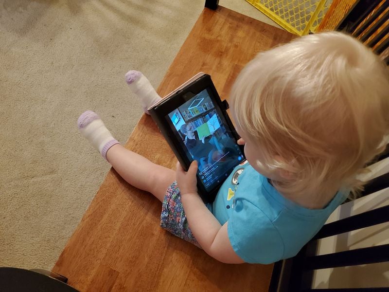 Aubry Oresteen, 22 months, watches her favorite librarian on her parents’ iPad. Like the rest of the state, her family is under a stay at home order during the COVID-19 crisis. (Photo courtesy of Paul Oresteen)