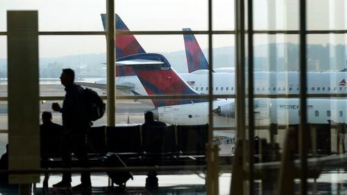 FILE - A person walks through the terminal as planes remain at gates at Ronald Reagan Washington National Airport in Arlington, Va., Wednesday, Jan. 11, 2023. (AP Photo/Patrick Semansky, File)