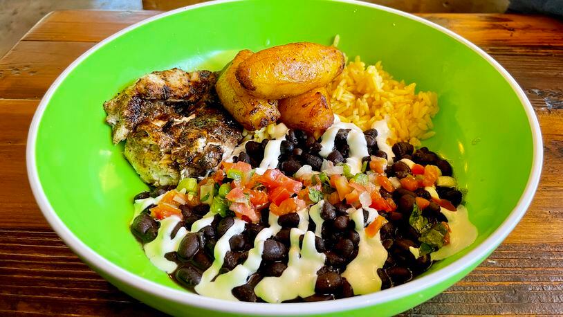 In the jerk chicken bowl at Wylie & Rum, the breast meat nestles with seasoned yellow rice and black beans, and is topped with pico de gallo and sour cream. Angela Hansberger for The Atlanta Journal-Constitution