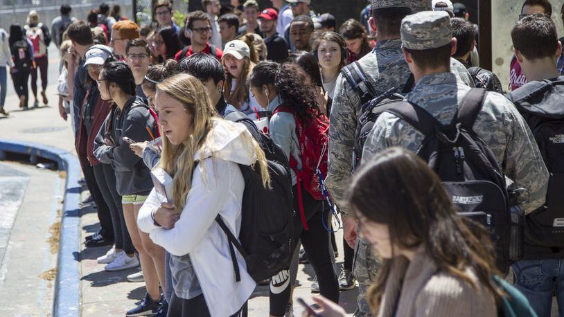 University of Georgia students wait for buses at the Tate Student Center bus stop on the University of Georgia campus in Athens, Georgia, on Tuesday, April 17, 2018. (REANN HUBER/REANN.HUBER@AJC.COM)