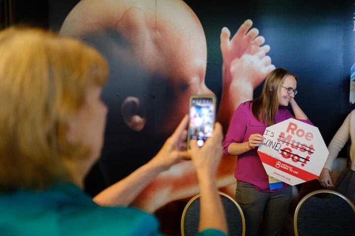 A volunteer with National Right to Life holds a sign that has been adjusted to say “Roe is Gone” at the National Right to Life Convention at the Airport Marriott Hotel in Atlanta on Friday, June 24, 2022, the day the U.S. Supreme Court overturned Roe v. Wade. (Arvin Temkar / arvin.temkar@ajc.com)