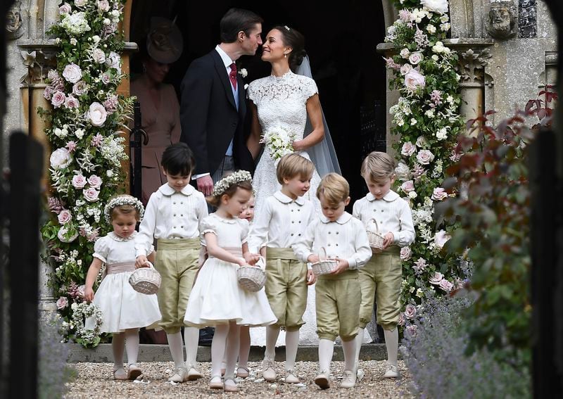 Pippa Middleton, background right, kisses James Matthews after their wedding at St Mark's Church in Englefield, England, Saturday, May 20, 2017. Middleton, the sister of Kate, Duchess of Cambridge married hedge fund manager James Matthews in a ceremony Saturday where her niece and nephew Prince George and Princess Charlotte was in the wedding party, along with sister Kate and princes Harry and William. (Justin Tallis/Pool Photo via AP)