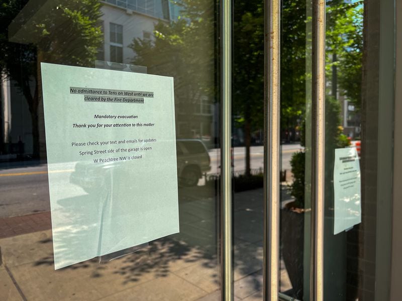 A sign on the entrance door to the Tens on West apartment complex in Midtown on Wednesday after the building was evacuated due to a partial crane collapse at a construction site next door.