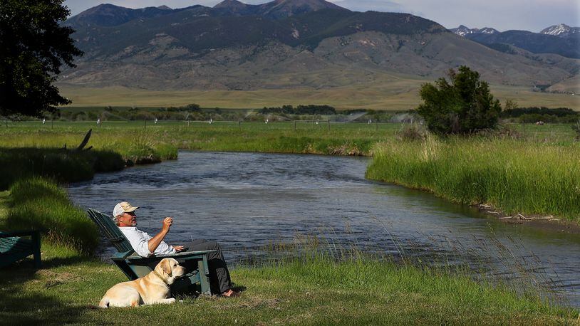 The wide-open spaces are outside Steve Bartkowski's back door in Montana - here he takes in the view from the banks of the Ruby River with the family dog Kua last summer. (Curtis Compton/ccompton@ajc.com