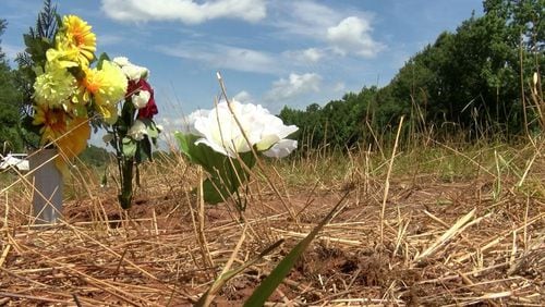 Flowers are placed at the site of a deadly crash in southern Alabama that killed a Georgia 8-year-old, his mother and a teenage driver.