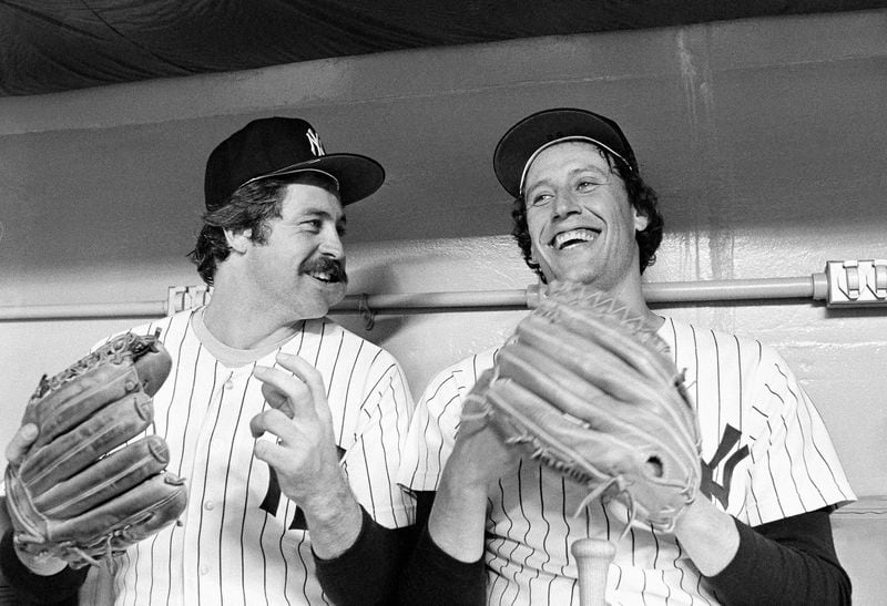 FILE - New York Yankee hurlers Jim Catfish Hunter, left, and Ken Holtzman are all smiles prior to the start of second American League playoff game between the Yankees and the Kansas City Royals at Yankee Stadium, Oct. 6, 1977, New York. Holtzman, who pitched two no-hitters for the Chicago Cubs and helped the Oakland Athletics win three straight World Series championships in the 1970s, has died, the Cubs announced Monday April 15, 2024, on social media. (AP Photo/Harry Harris, File)