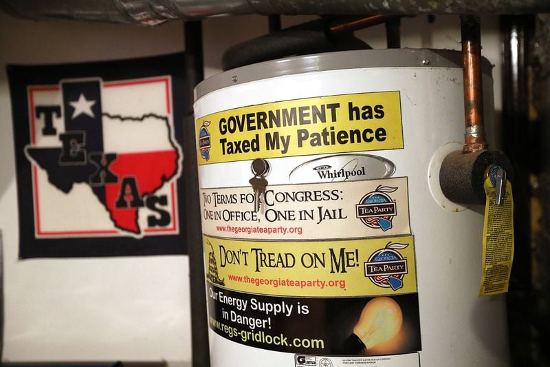 West’s water heat is covered with political bumper stickers at his home in Kennesaw. Curtis Compton/ccompton@ajc.com