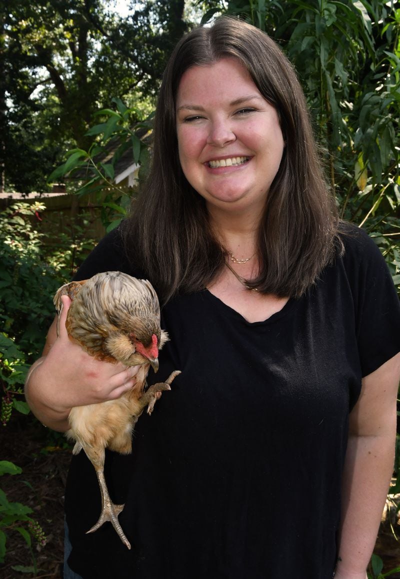 Taylor Mead, market manager at the Ponce City Farmers Market, holds her favorite egg-laying hen, Alice, who was named after Mead's grandmother. Taylor and her husband, who live in Atlanta, consider themselves "urban homesteaders." (Chris Hunt for the AJC)