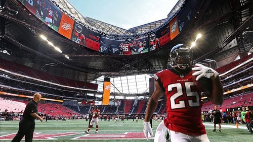 Falcons  coach Dan Quinn looks on as running back Ito Smith and teammates prepare to play  Tampa Bay Buccaneers with the roof of Mercedes-Benz Stadium open on Oct. 14.