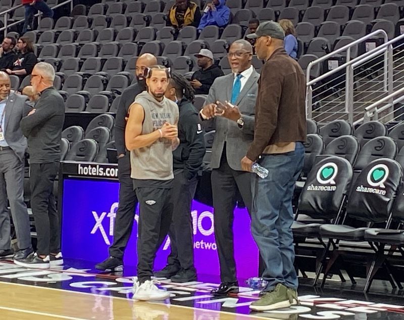 New Orleans Pelicans guard Jose Alvarado (in gray shirt) visits with Hawks legend and TV color analyst Dominique Wilkins (center) and former Hawks all-star Kevin Willis (right) prior to the Hawks' game against New Orleans March 10, 2024 at State Farm Arena. Wilkins has followed Alvarado since his days at Georgia Tech. Wilkins called Alvarado a little fireplug and said that "I always respect guys like that, that have a motor, that bring it, don’t complain. They just play the game of basketball. I really love Alvarado and the way he plays." AJC photo by Ken Sugiura