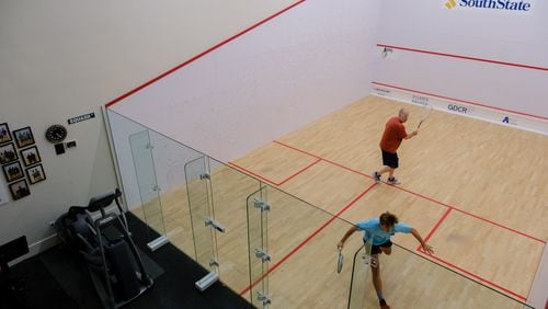 Jonathan McMurry plays squash with his 16-year-old son Sam at their home squash court in Marietta. In August, McMurry will begin a yearlong sabbatical during which he plans to focus on his health and figure out then next stage in his career.  (Arvin Temkar / arvin.temkar@ajc.com)