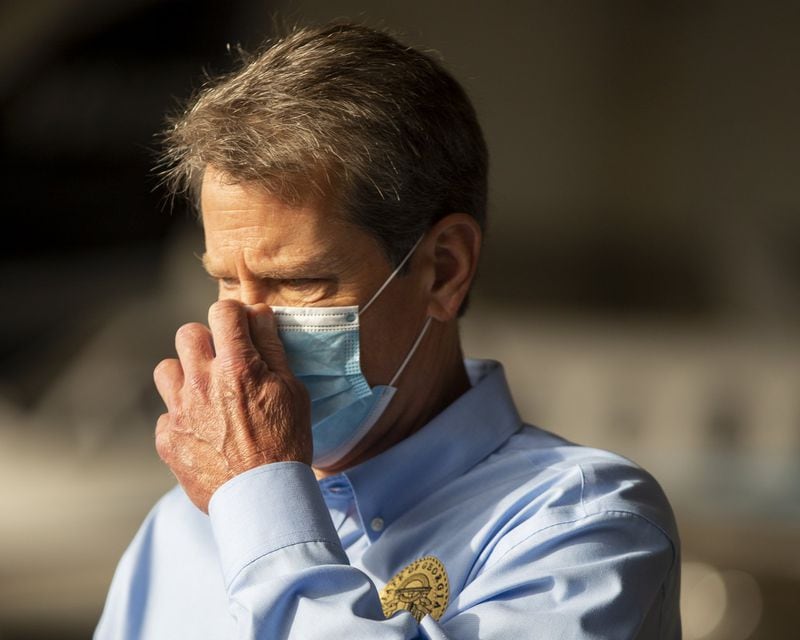 Georgia Gov. Brian Kemp adjusts his mask at the Peachtree Dekalb Airport in Atlanta, Georgia, on July 1, 2020. REBECCA WRIGHT FOR THE AJC