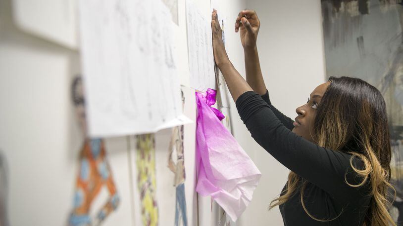 Savannah College of Art and Design senior Ronnita Whipple hangs up her designs at the campus in Atlanta on Monday, Feb. 26, 2018. ALYSSA POINTER/ALYSSA.POINTER@AJC.COM
