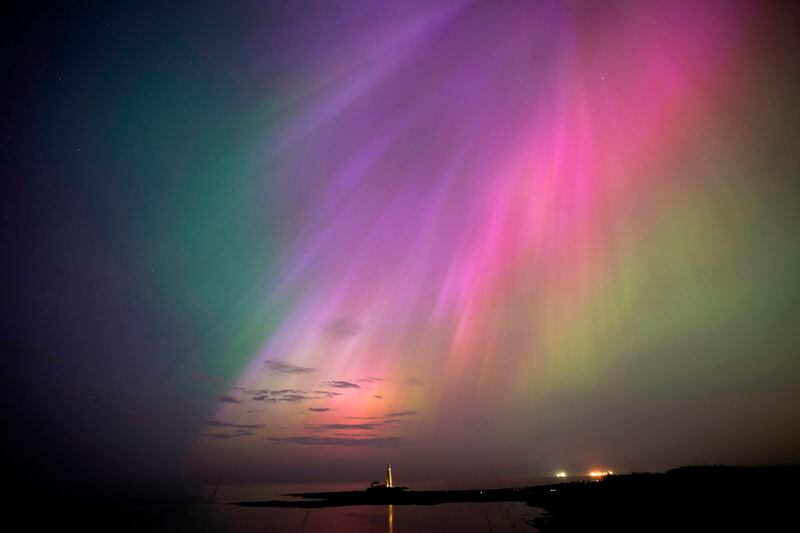 The aurora borealis, also known as the northern lights, glow on the horizon at St. Mary's Lighthouse in Whitley Bay on the North East coast, England, Friday, May 10, 2024. (Owen Humphreys/PA via AP)