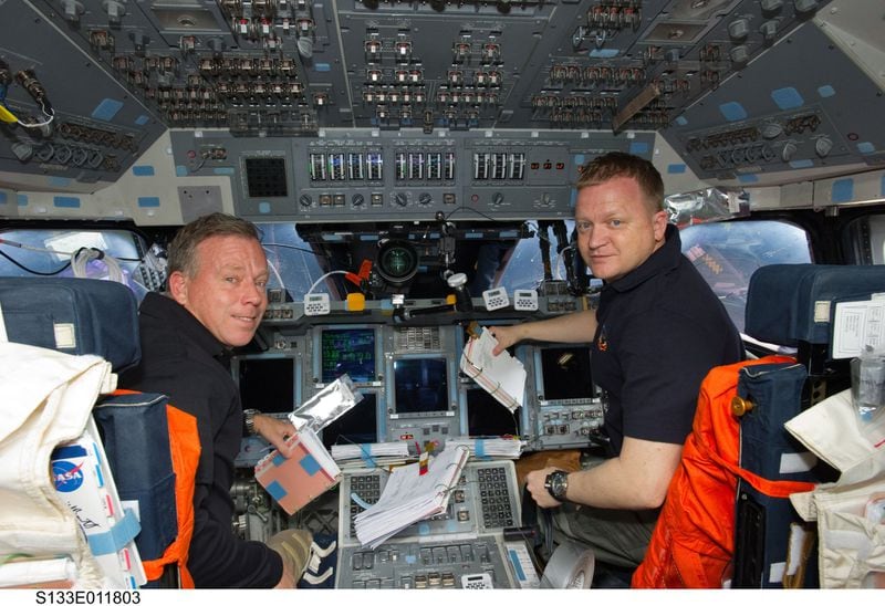 In this photo taken March 7, 2011, NASA astronauts Steve Lindsey (left), STS-133 commander; and Eric Boe, pilot, are pictured at their respective stations on the forward flight deck of space shuttle Discovery during flight day 12 activities. Photo credit: NASA
