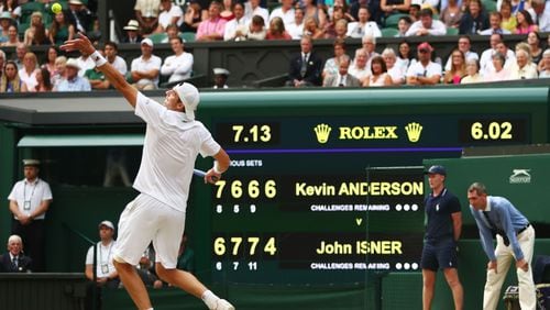 John Isner serves against Kevin Anderson in front of the scoreboard during their Men's Singles semi-final match on day eleven of the Wimbledon Lawn Tennis Championships at All England Lawn Tennis and Croquet Club on July 13, 2018, in London.
