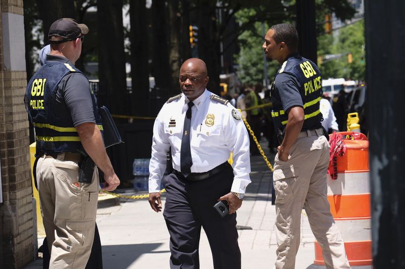 Atlanta police Chief Rodney Bryant arrives at the scene of the police shooting in Midtown. He said the injured officer is conscious and doing well after being shot in the face on the eighth floor of the apartment building. 