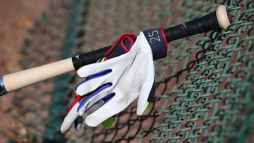 The bat and glove of Braves catcher Tyler Flowers lean against a fence during spring training at Disney’s ESPN Wide World of Sports. (Curtis Compton / ccompton@ajc.com)