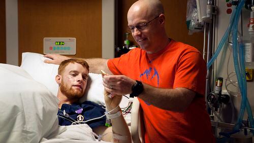 Lance Cpl. Alex Juedes of Marietta is visited by his father Greg Juedes of Powder Springs at Walter Reed National Medical Center in Maryland.