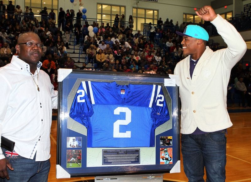 Cam Newton (right) has his jersey retired by Westlake High School in 2013.