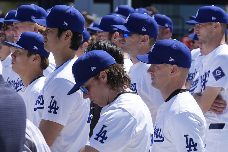 Los Angeles Dodgers pitchers Shohei Ohtani, left, celebrates Jackie Robinson Tribute Day alongside teammates before a baseball game against the Washington Nationals at Dodgers Stadium in Los Angeles on Monday, April 15, 2024. (AP Photo/Damian Dovarganes)