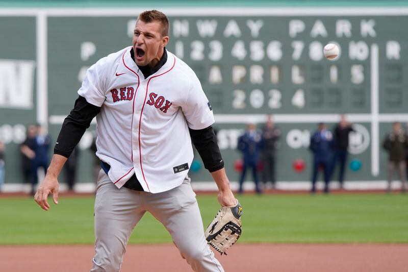 Former New England Patriots NFL football player Rob Gronkowski reacts after spiking the ball instead of throwing it during the ceremonial first pitch before a baseball game between the Boston Red Sox and the Cleveland Guardians, Monday, April 15, 2024, in Boston. (AP Photo/Michael Dwyer)