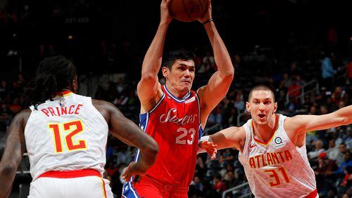 Ersan Ilyasova #23 of the Philadelphia 76ers drives between Taurean Prince #12 and Mike Muscala #31 of the Atlanta Hawks at Philips Arena on March 30, 2018 in Atlanta, Georgia.  NOTE TO USER: User expressly acknowledges and agrees that, by downloading and or using this photograph, User is consenting to the terms and conditions of the Getty Images License Agreement.  (Photo by Kevin C. Cox/Getty Images)