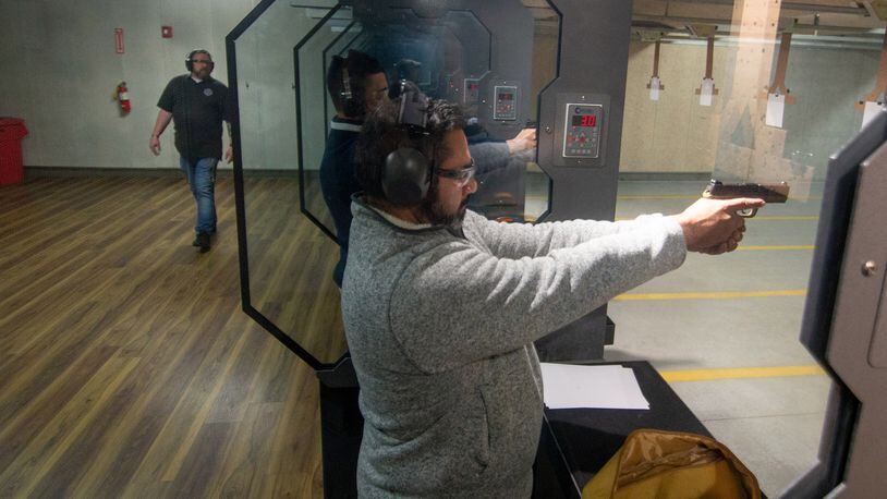 Mark Cano fires his handgun at the range as instructor Kyle Klyncko looks on during a Saturday morning handgun training class at Georgia Gun Club in Buford on January 23, 2021.  STEVE SCHAEFER FOR THE ATLANTA JOURNAL-CONSTITUTION